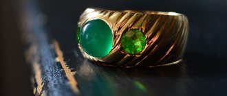 Широкое золотое кольцо с демантоидом и другими зелёными камнями в огранке и мутноватым зелёным кабошоном в центре